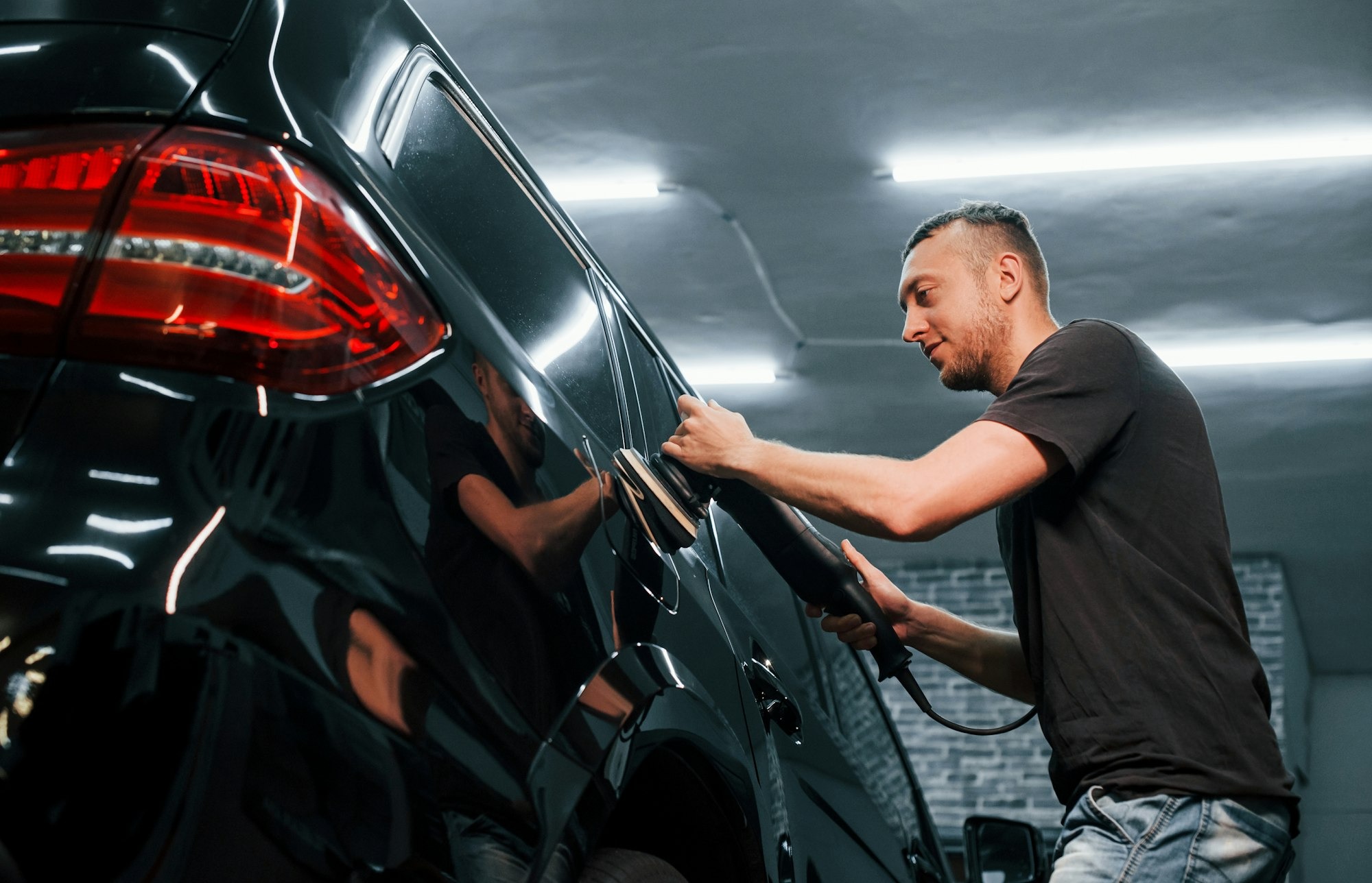 imgi 31 modern black automobile get cleaned by man inside of car wash station